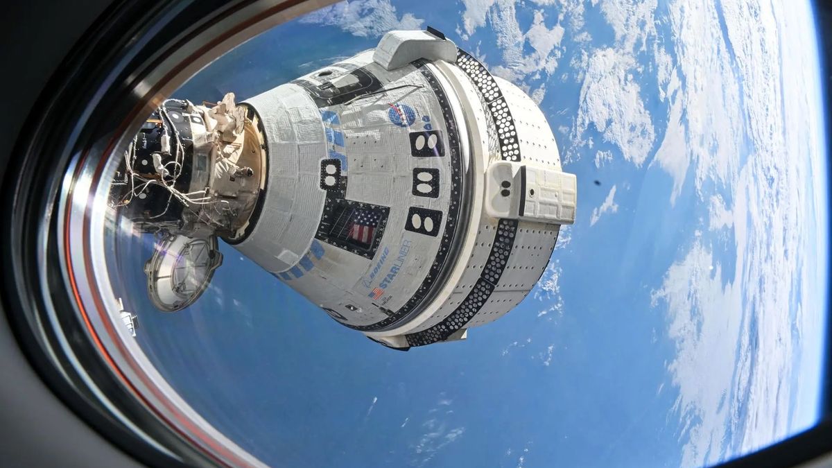 a white space capsule is seen through a spacecraft window, with earth in the background