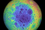 A giant orb takes up the majority of the image, bordered on either sitde by black. Its face is riddled with craters, with colors blotched throughout in vibrant blues, greens, yellows, and reds.